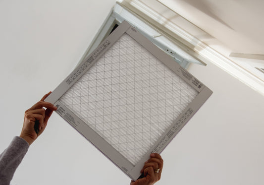 Homeowner woman changing home air conditioning filters since it’s important to do it as recommended